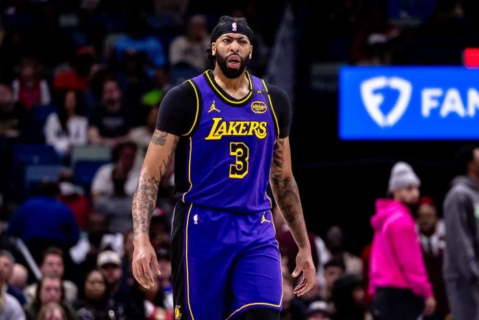 Former Lakers star Anthony Davis in a Lakers uniform looking slightly befuddled in front of a crowd in a stadium.