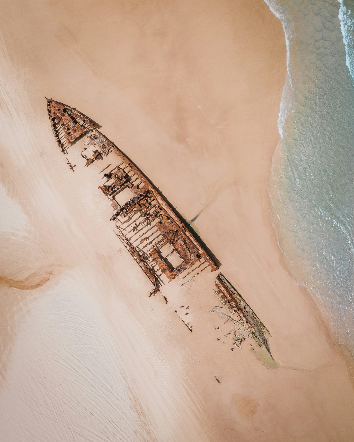 Hull of wrecked ship buried in sand