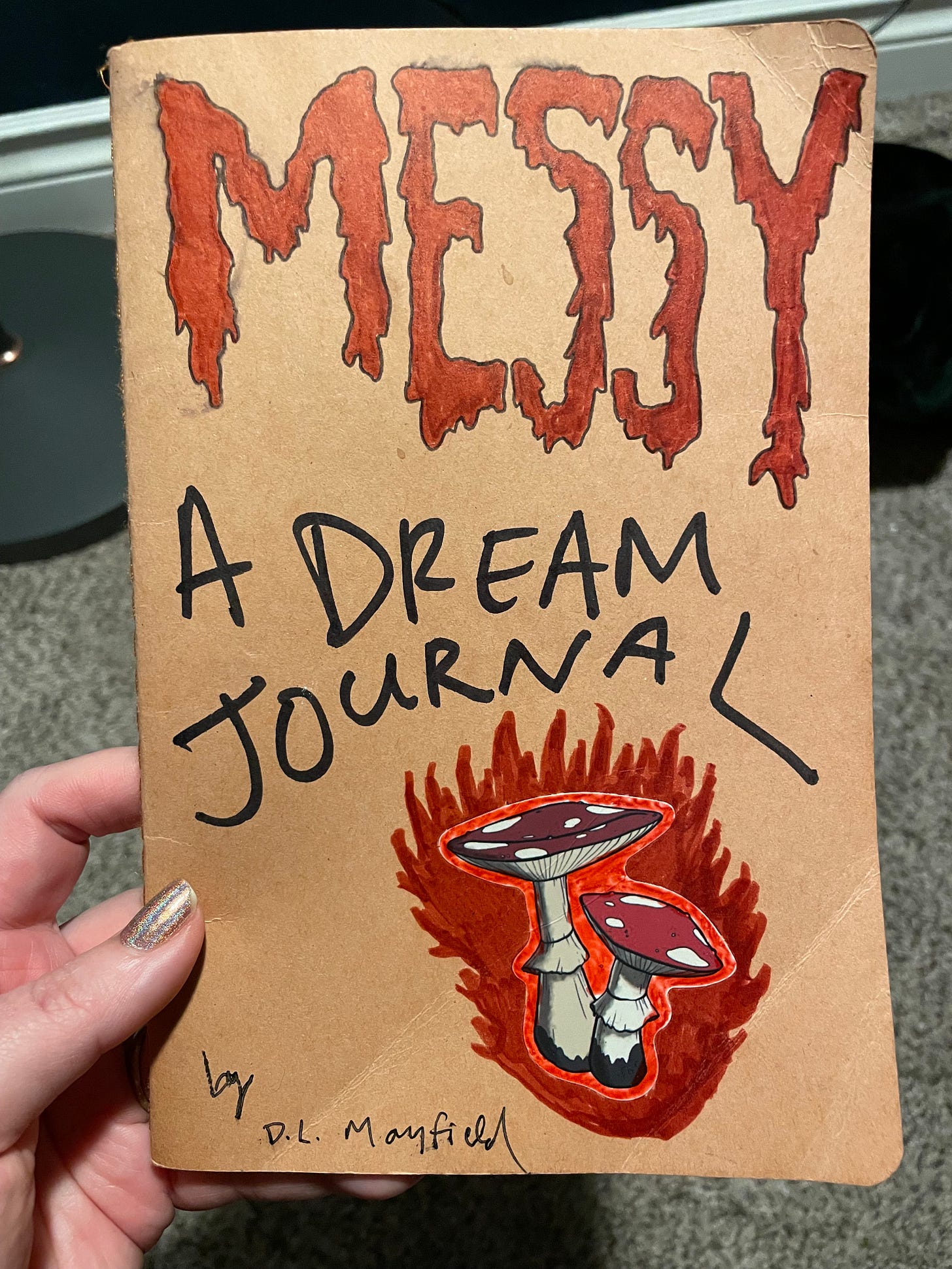 a brown paper journal with stickers of mushrooms on it says messy a dream journal by dl mayfield