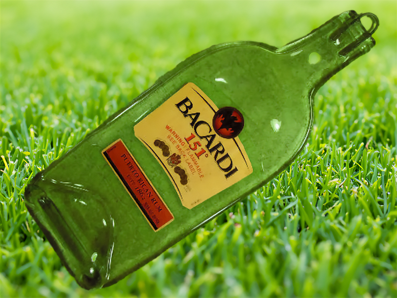 Empty bottle of Bacardi 151 laying on a lawn. Dall-E 3 prompt, altered by author.