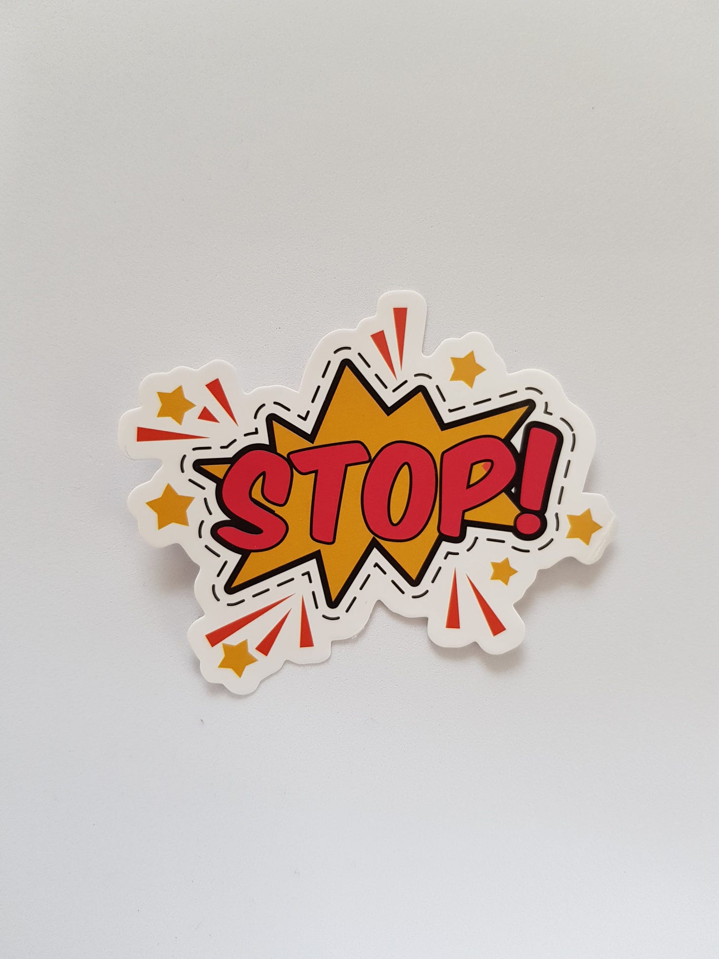 A comic book style sticker of the word “STOP!”