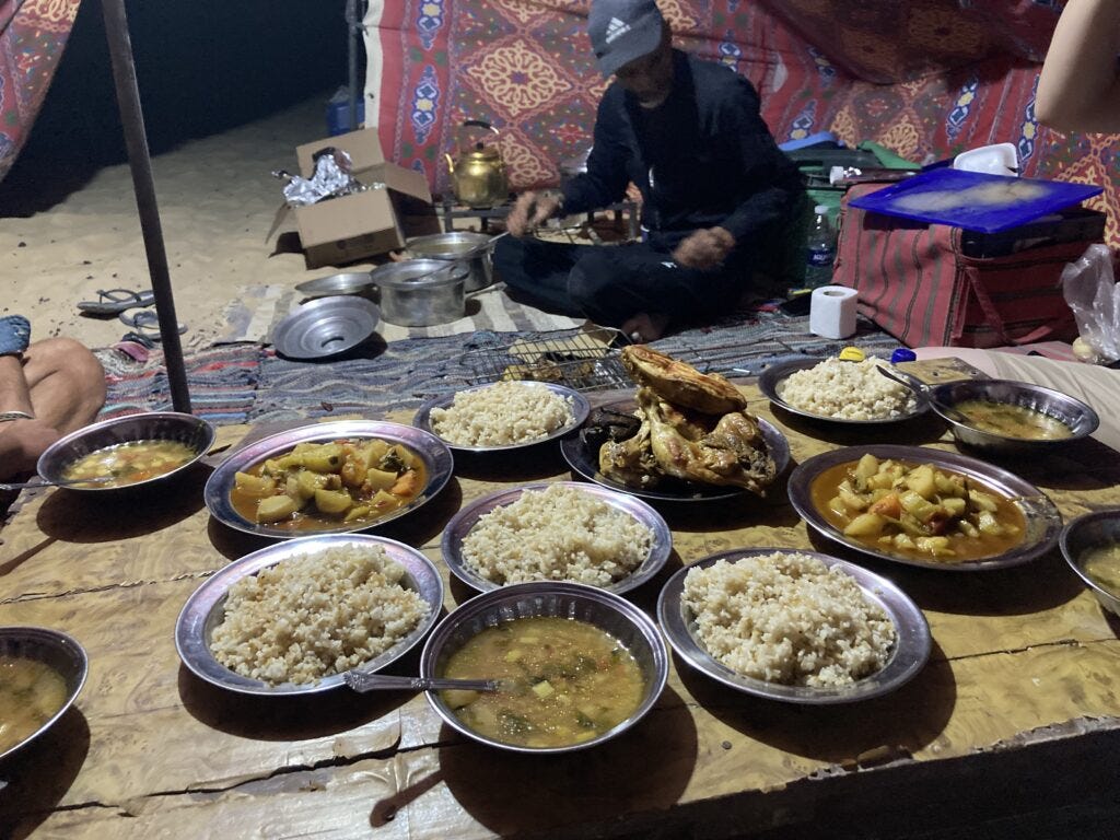 Tour guide setting up dinner of rice, chicken, and vegetable stew on the White Desert Tour.