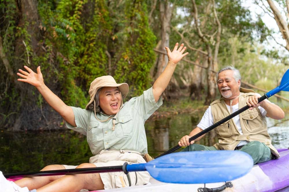 Elder couple enjoying an outdoor kayaking adventure together.