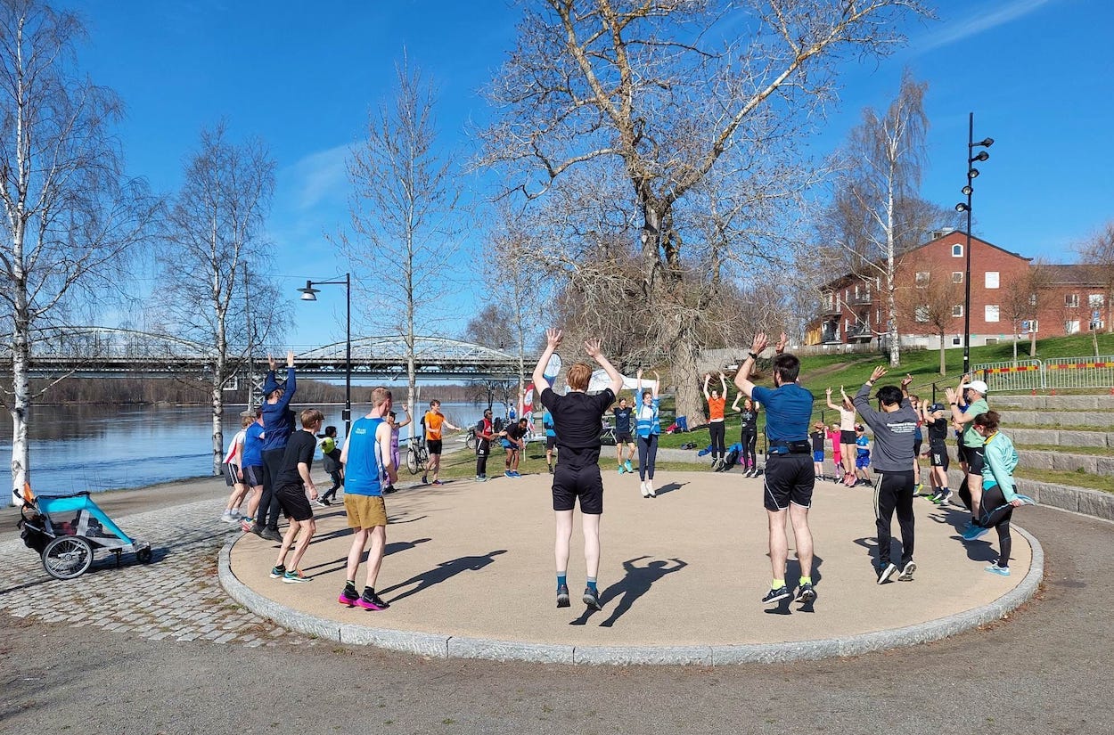 Participants standing on a large flat stone circle for a warm up