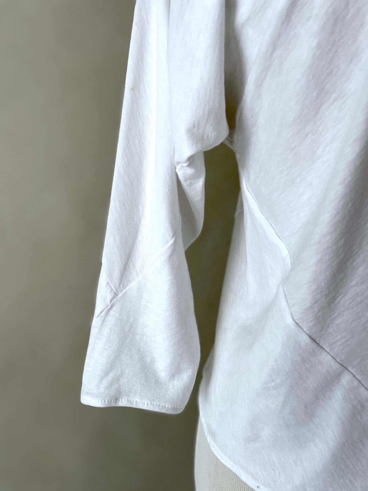 Close-up of the left sleeve of the 6-Square Top in white C4 cotton jersey