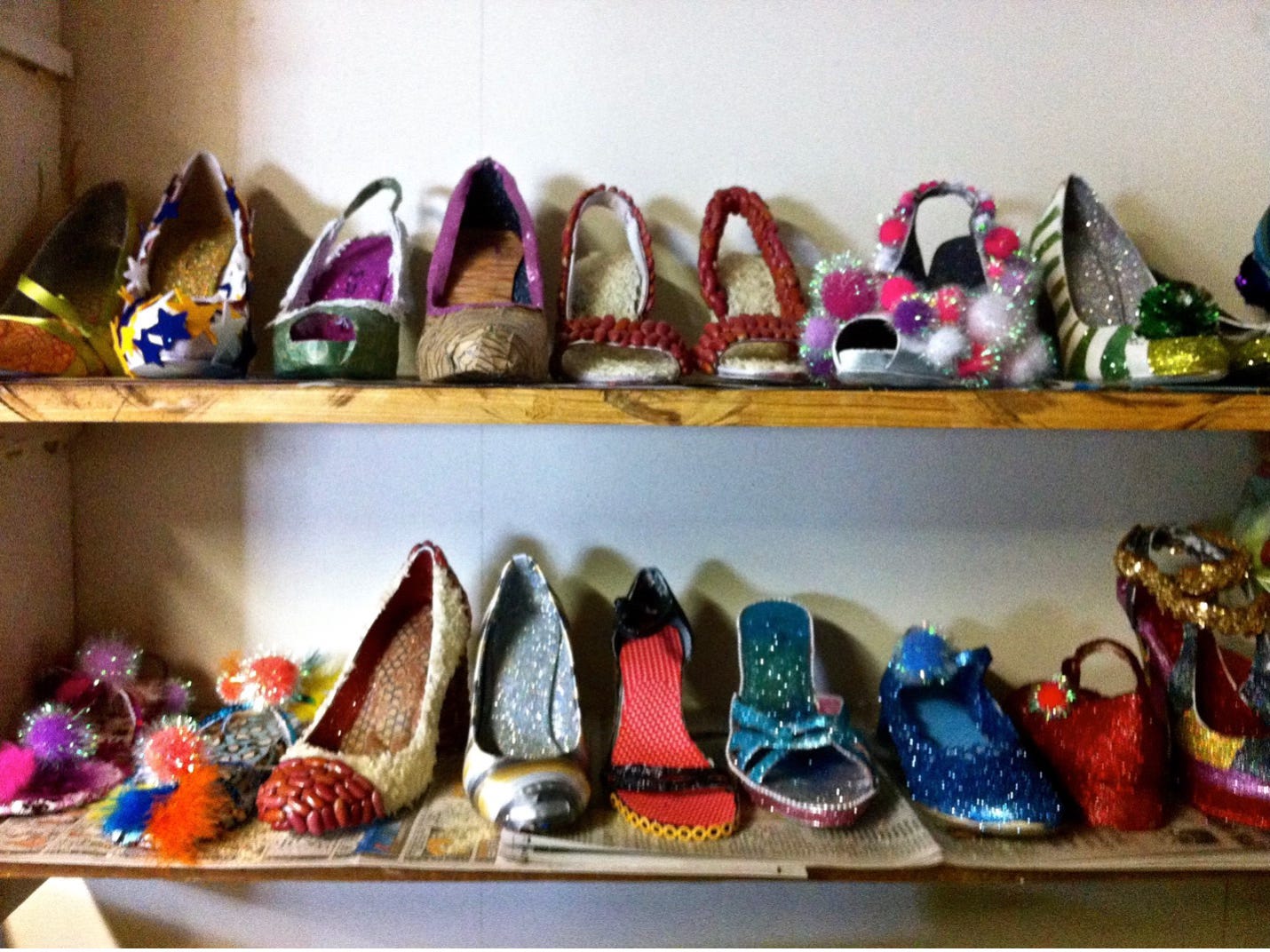 Two shelves of glittered and bedazzled shoes for the Muses Mardi Gras parade