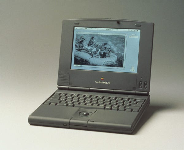 Picture of the Apple PowerBook Duo 250 laptop. The display is showing a picture of people white water rafting.