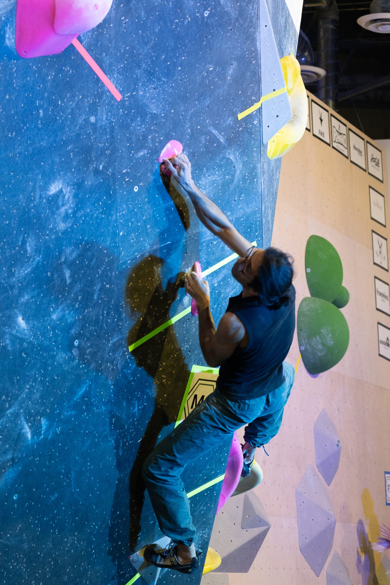 A climber hangs onto crimps, right heel hooked on the start hold and left toe pressing hard.