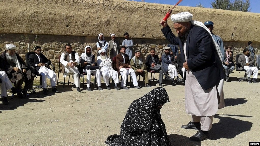 An Afghan judge hits a woman with a whip in front of a crowd in Ghor Province. (file photo)