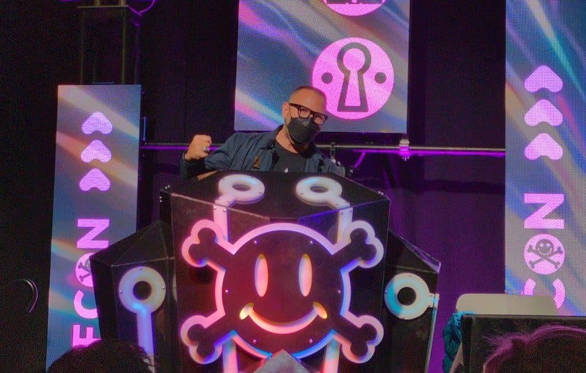 A photo of me at a podium at Defcon 32, giving my speech.