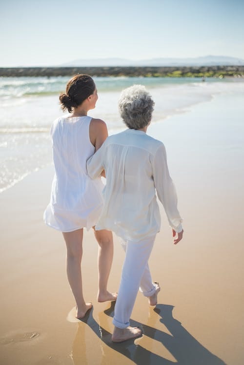Free Elderly Woman Holding on Another Woman While Walking at the Beach Stock Photo