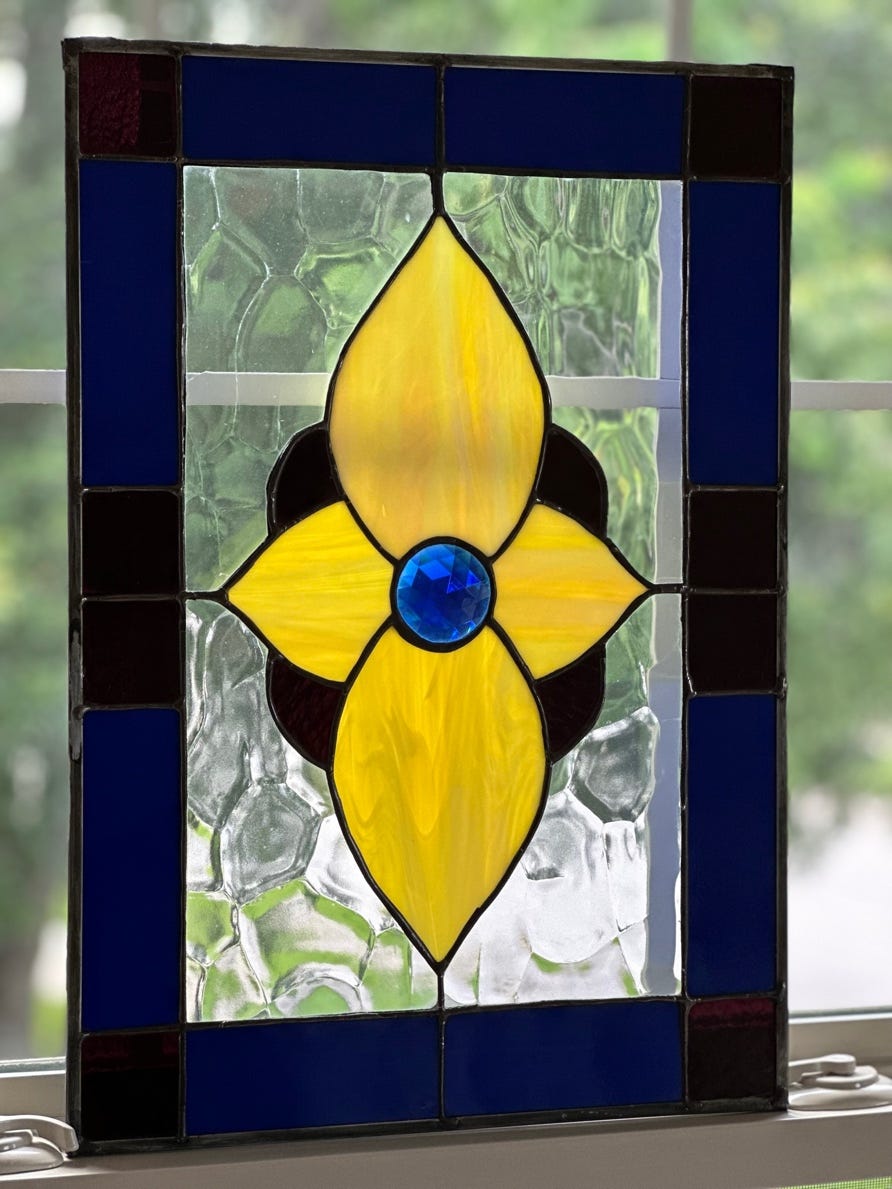 A stained glass window with a flower

Description automatically generated