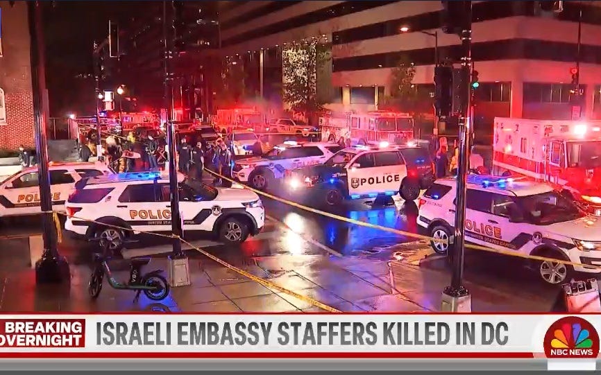 Video screenshot showing nighttime scene of a DC intersection full of police cars, fire trucks, and ambulances, streets blocked with crime tape. The scene is tinted red by all the emergency vehicle flashers.