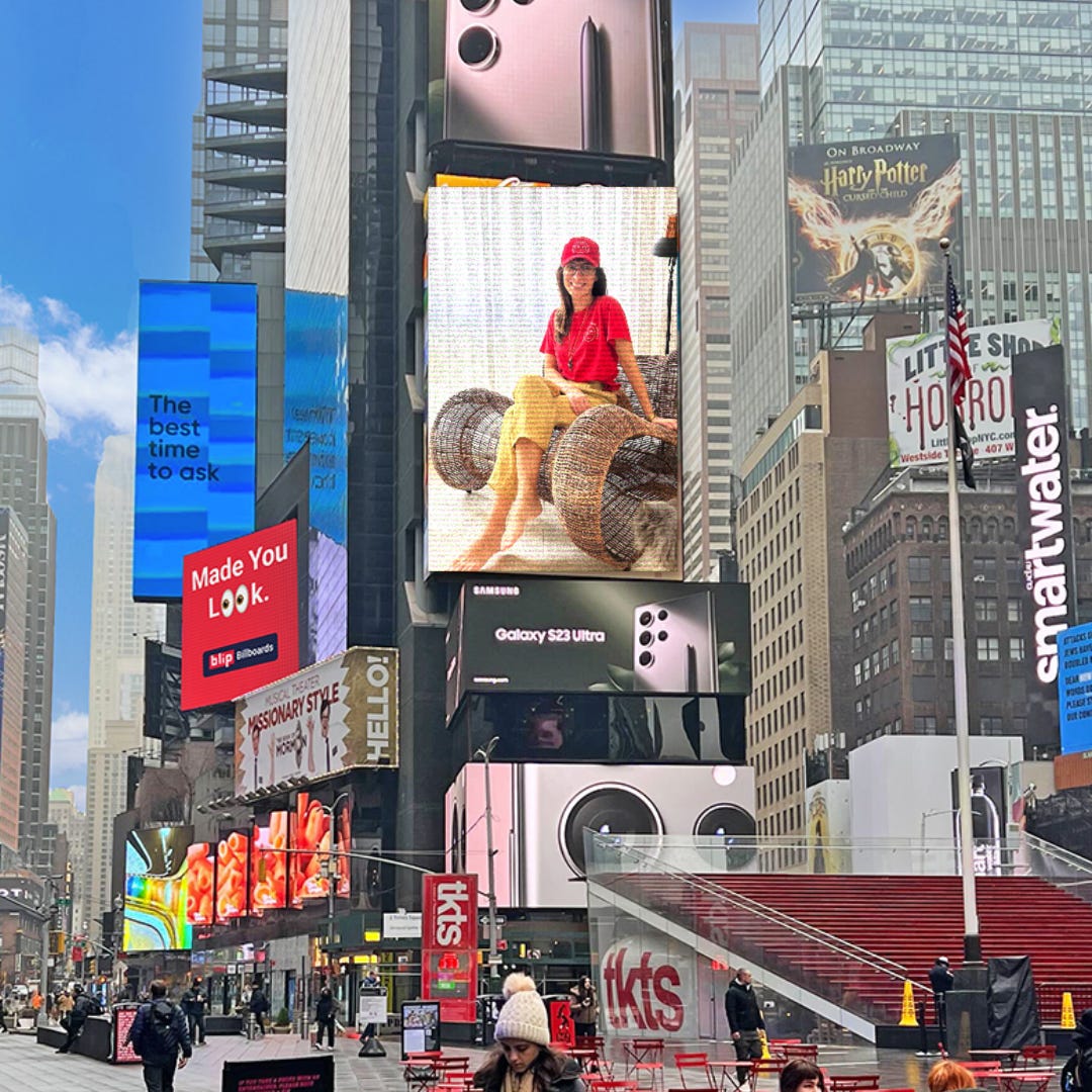 Montagem com uma imagem da Times Square e uma foto da Camila, usando o uniforme sem Carisma, em um dos telões
