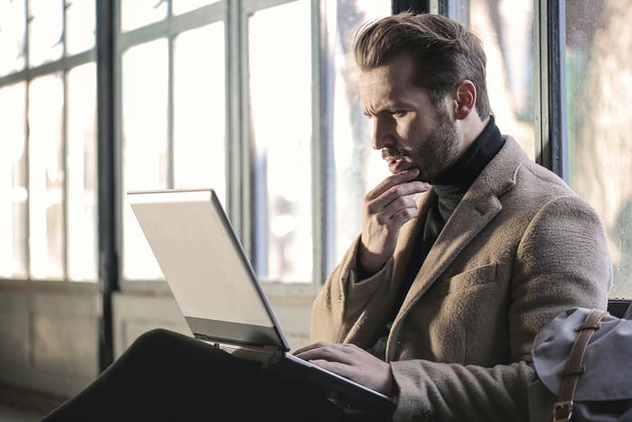 A man staring at a laptop screen with his mouth open, as if he doesn’t know how to make heads or tails of what he’s looking at.