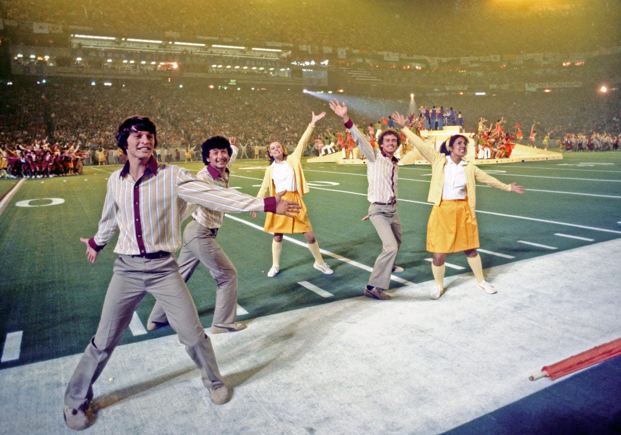 Members of the group Up With People perform on the field.