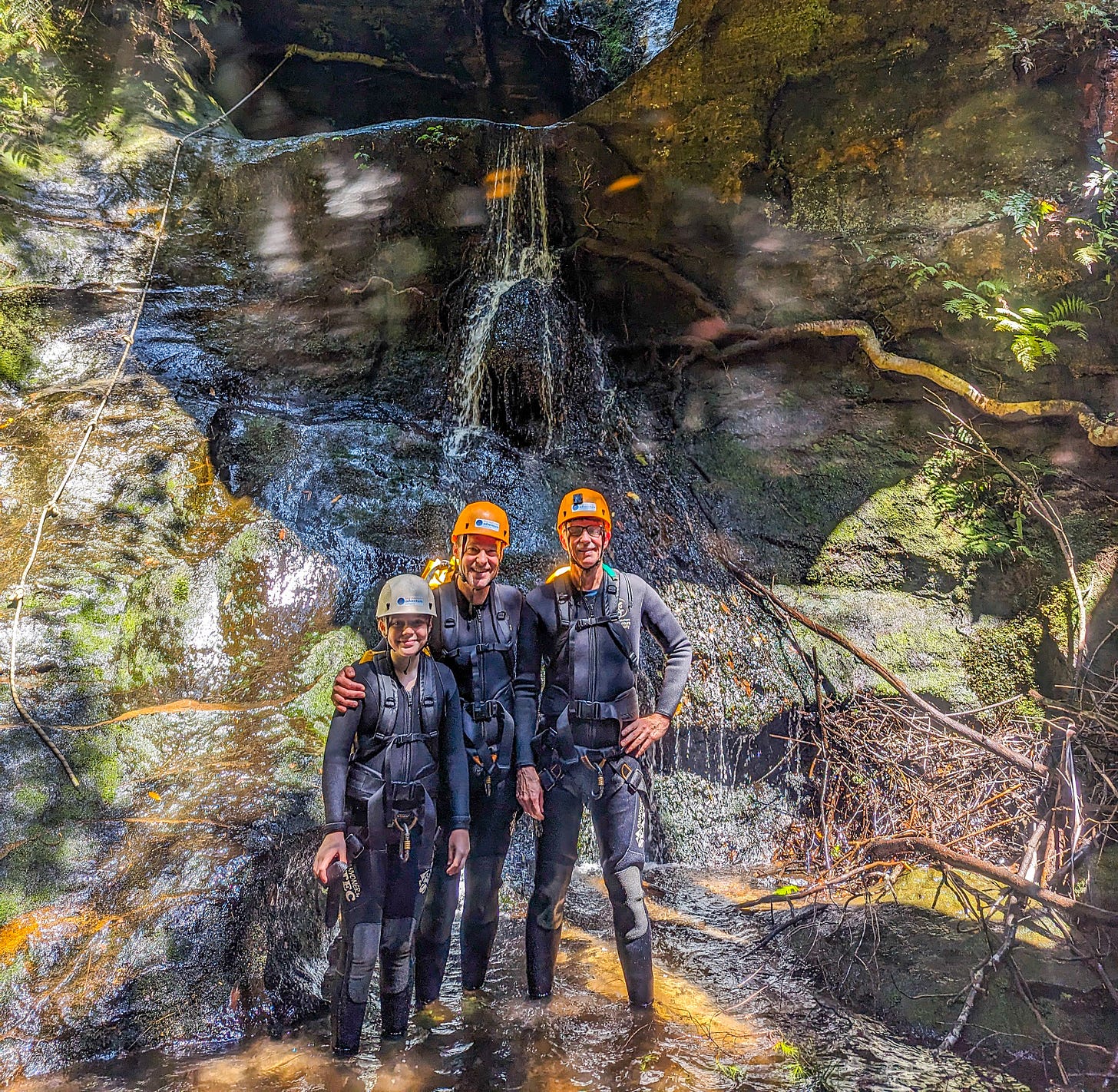 Michael, Gareth, and Jess standing in front of a waterfall wearing all of our equipment. 