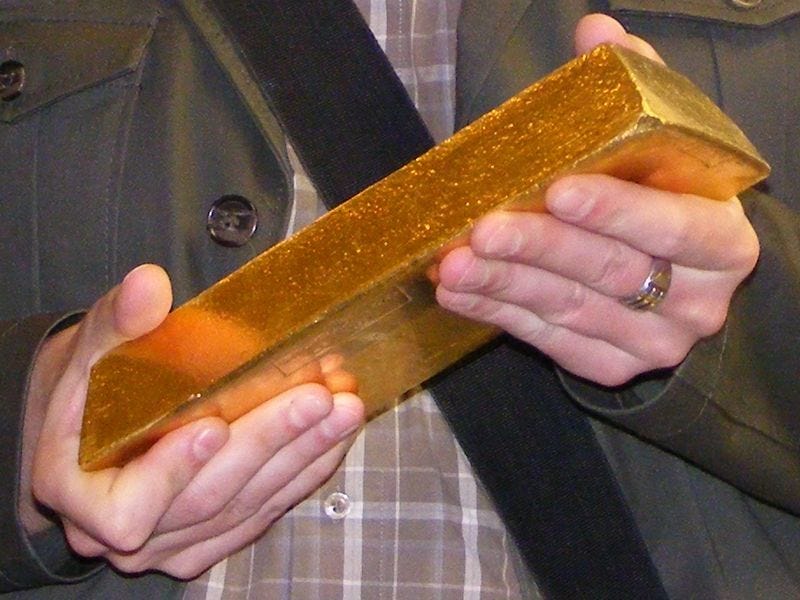photo of gold bar being held in man's hands