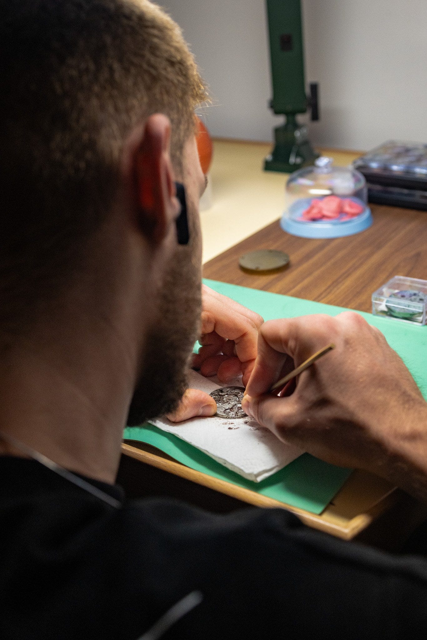 A watchmaker at Atelier 7H38 prepares a baseplate