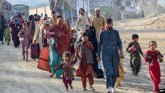 Afghan refugees in Pakistan walk towards the Pakistan-Afghanistan Torkham border crossing on November 3 following Pakistan's decision to expel people illegally staying in the country.