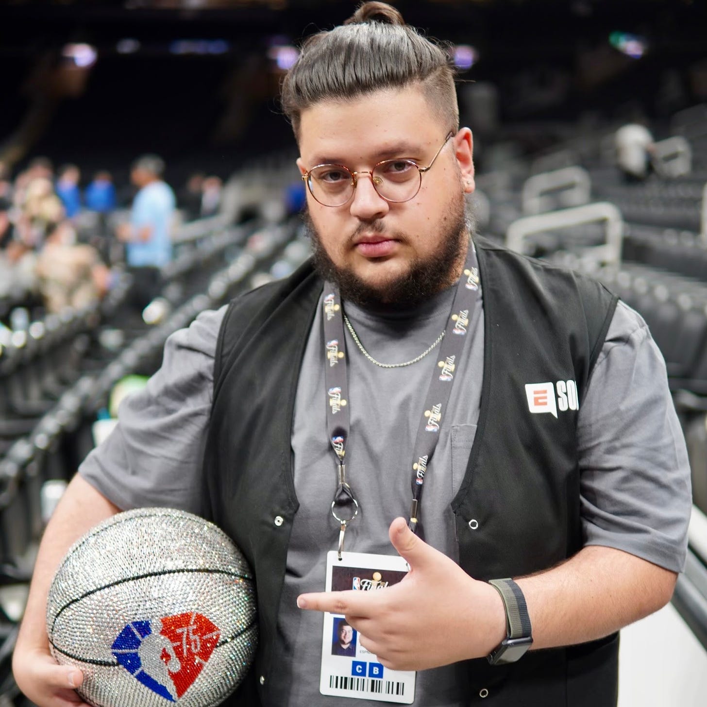 Photo of Moh Kloub, Senior Social Media Specialist at ESPN, standing in a stadium with a diamond encrusted basketball.