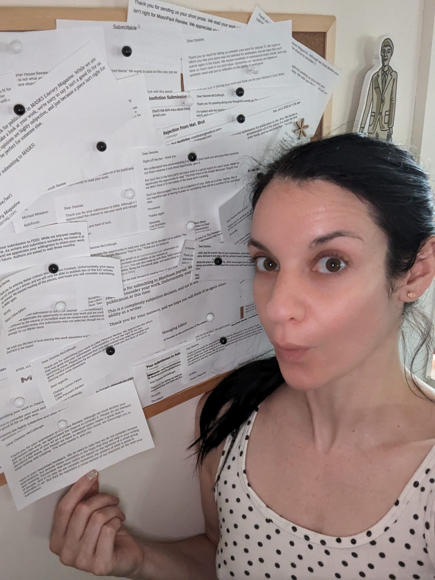 Women in front of board filled with printed out rejections from literary journals.