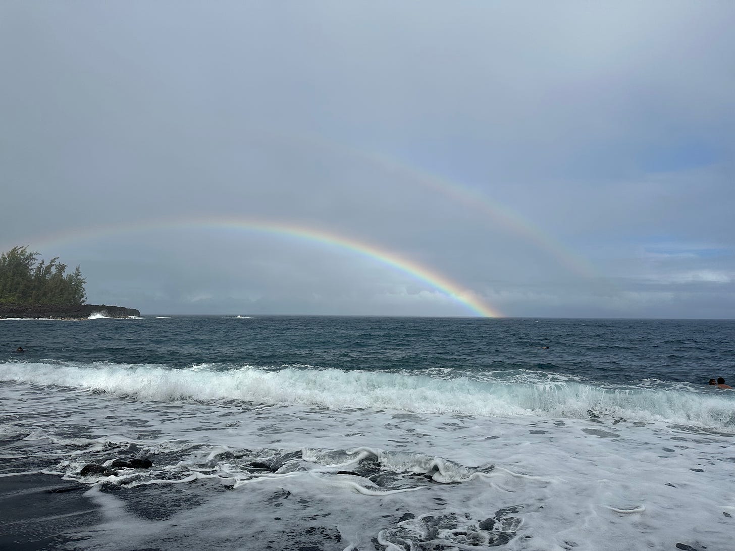 Photo of a double rainbow over the ocean taken at Kehena black sand beach in Hawai'i