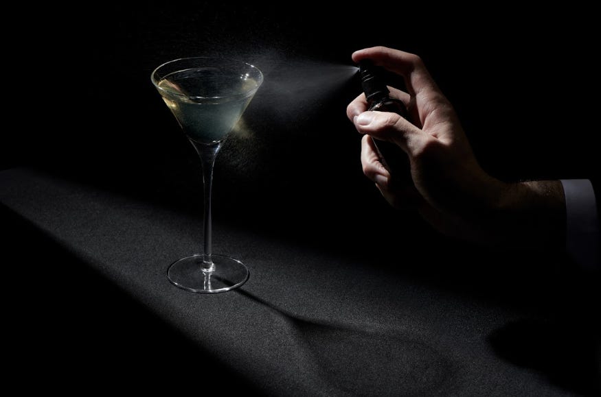 Someone spraying a cocktail