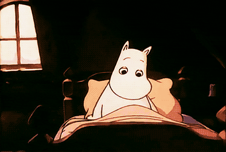 Gif of a Moomin sitting up in bed, stretching, and yawning.