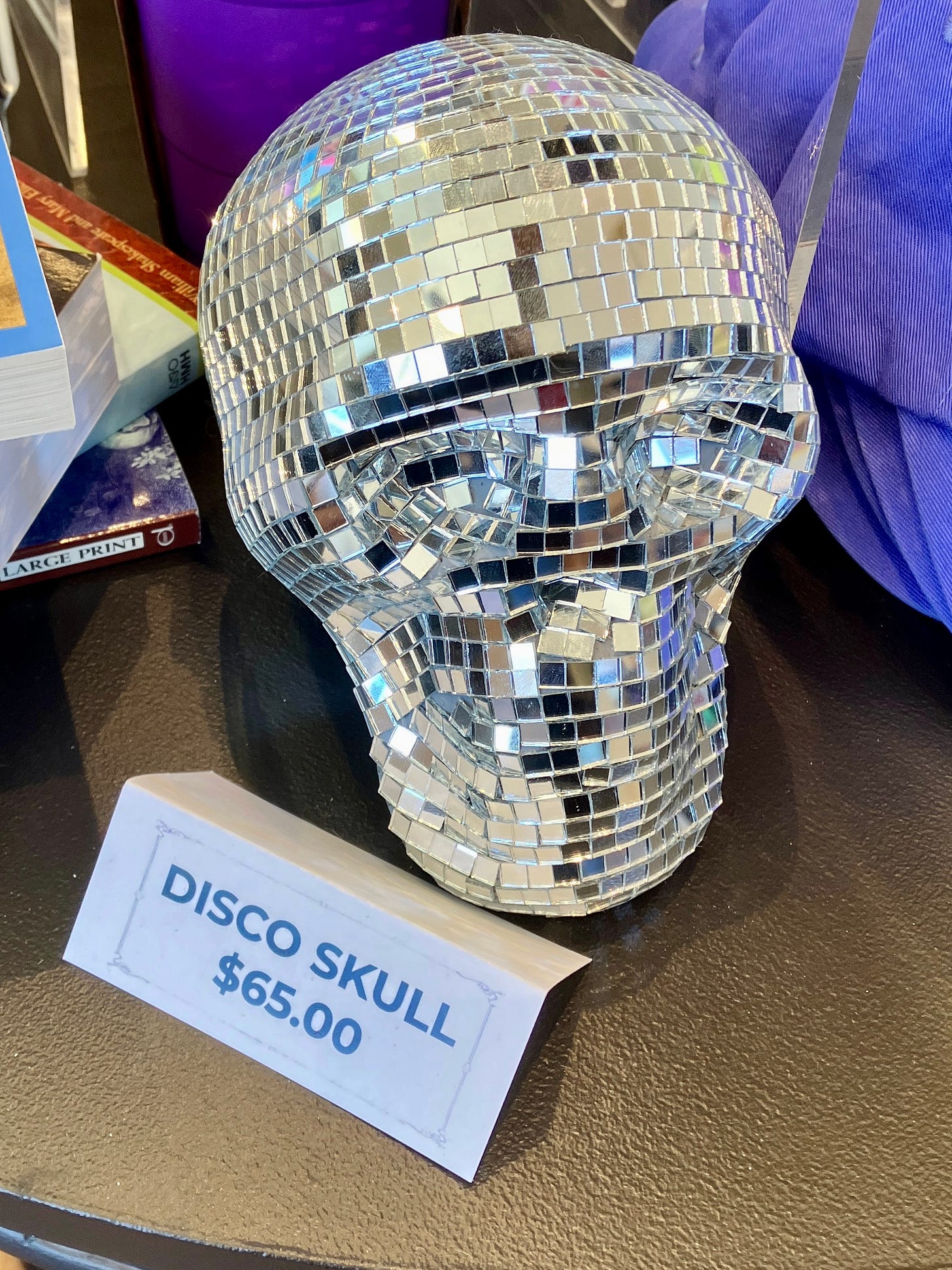 A disco ball in the shape of a skull, with a sign in front that says Disco Skull $65