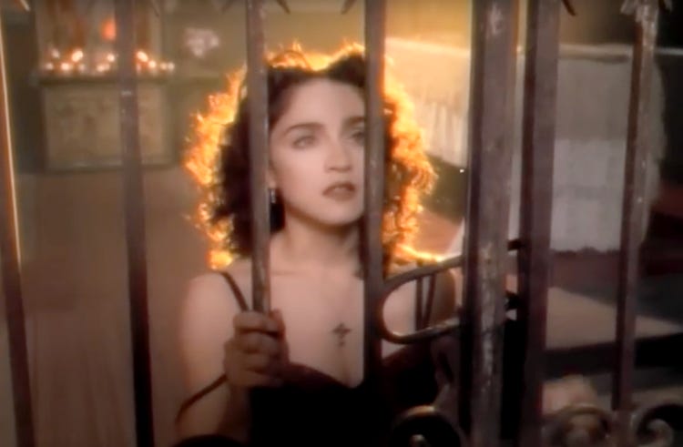 Madonna sits at gates looking at the saint