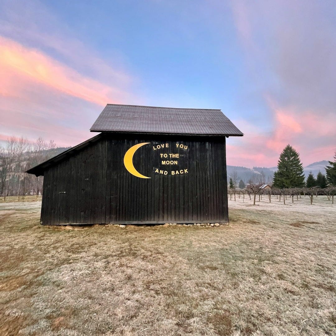 a black barn with a yellow crescent on it