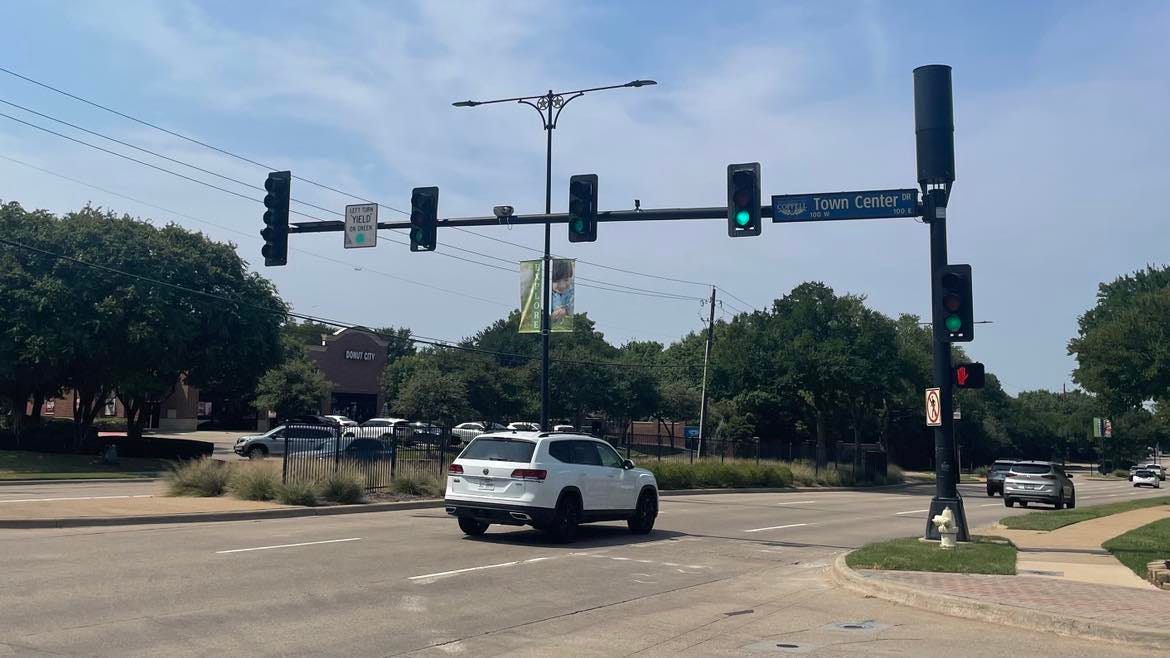 A set of traffic lights augmented by a vertical black cylinder