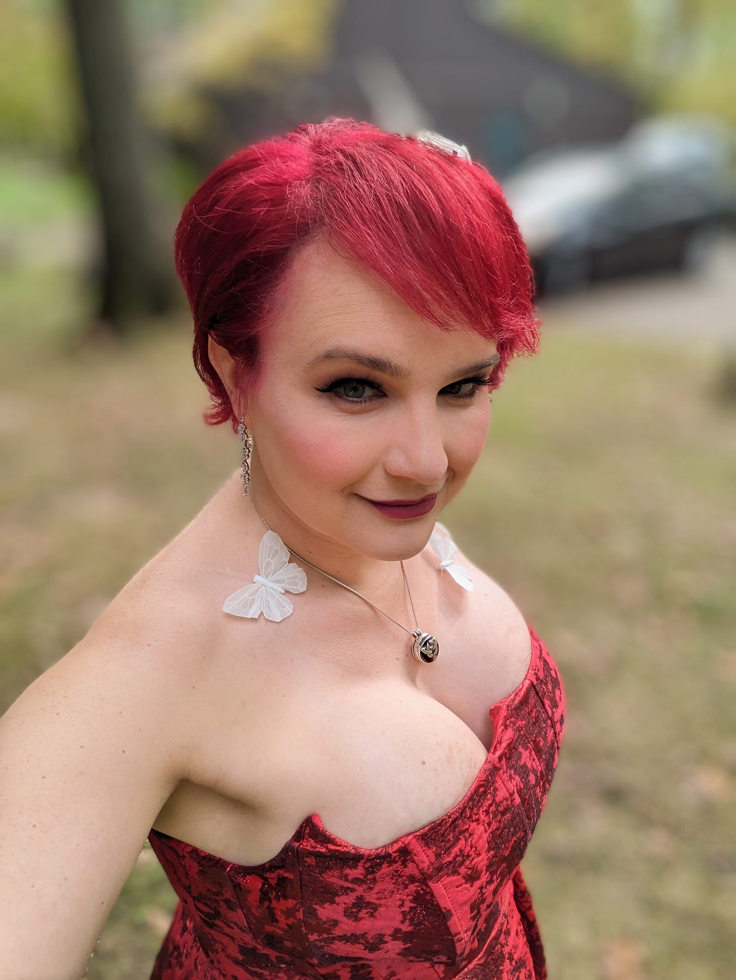 Zoe looks at the camera on her vow renewal day, wearing a red dress that exposes very full breasts and deep, deep cleavage.