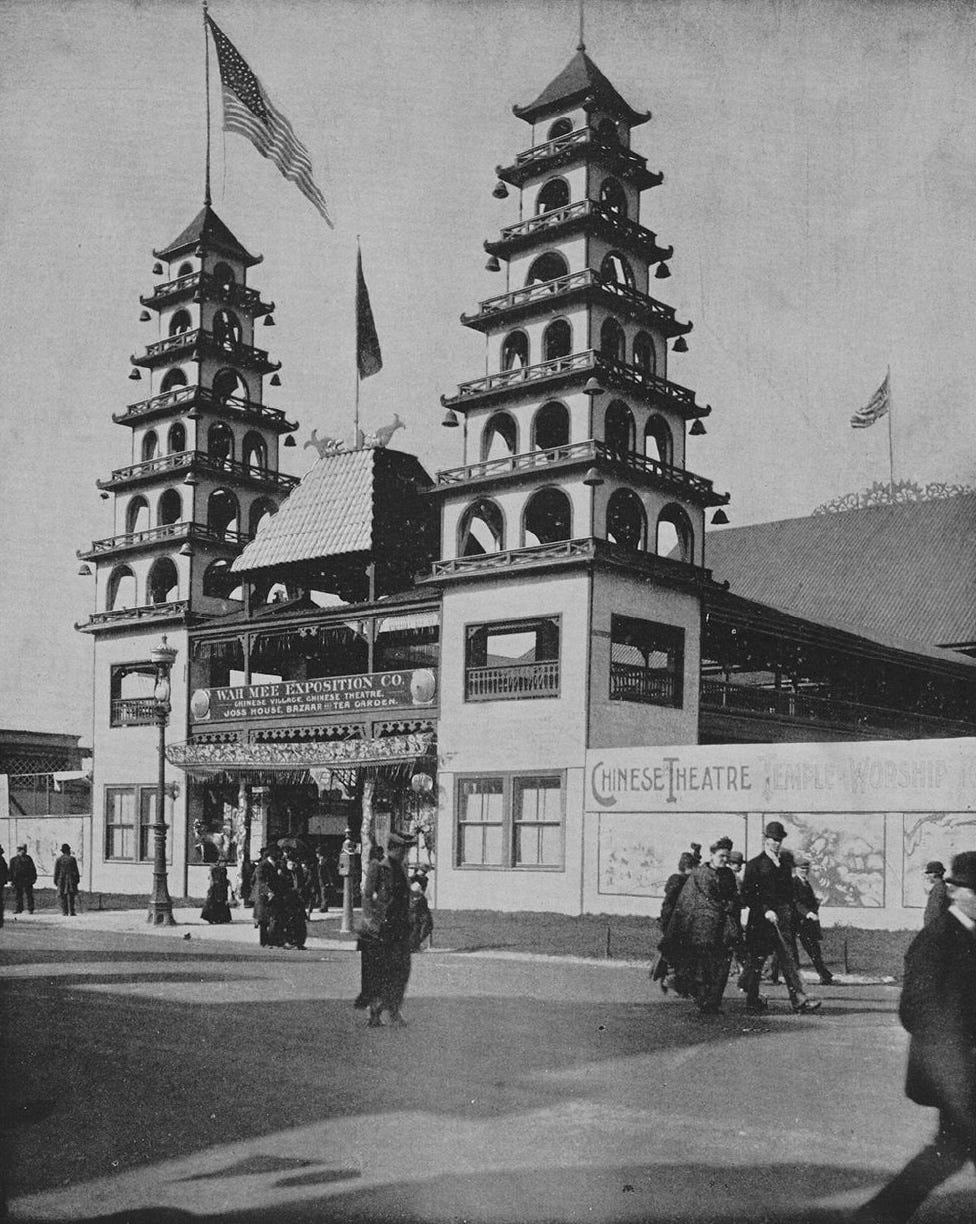 black and white photo of a building with two pagoda-like towers and American flags flying