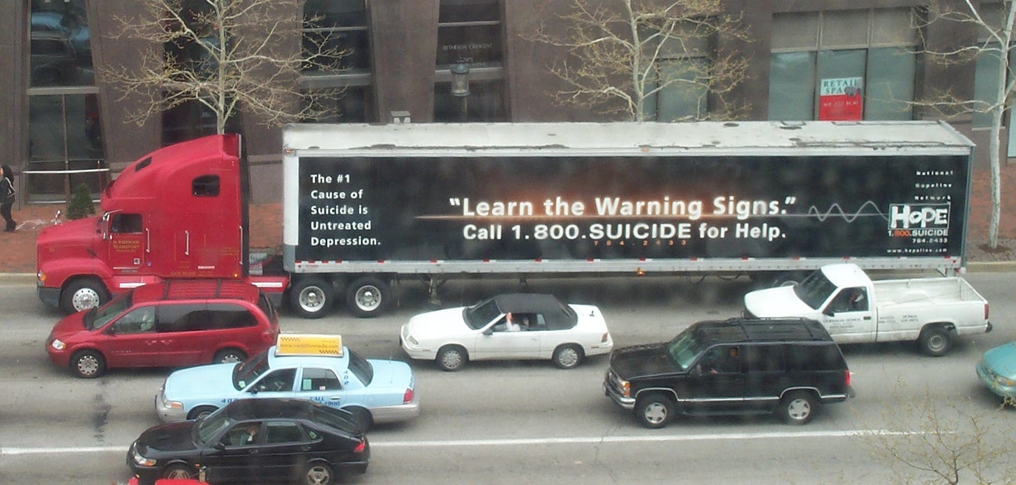 A tractor trailer with a 1.800.Suicide advertisement on it