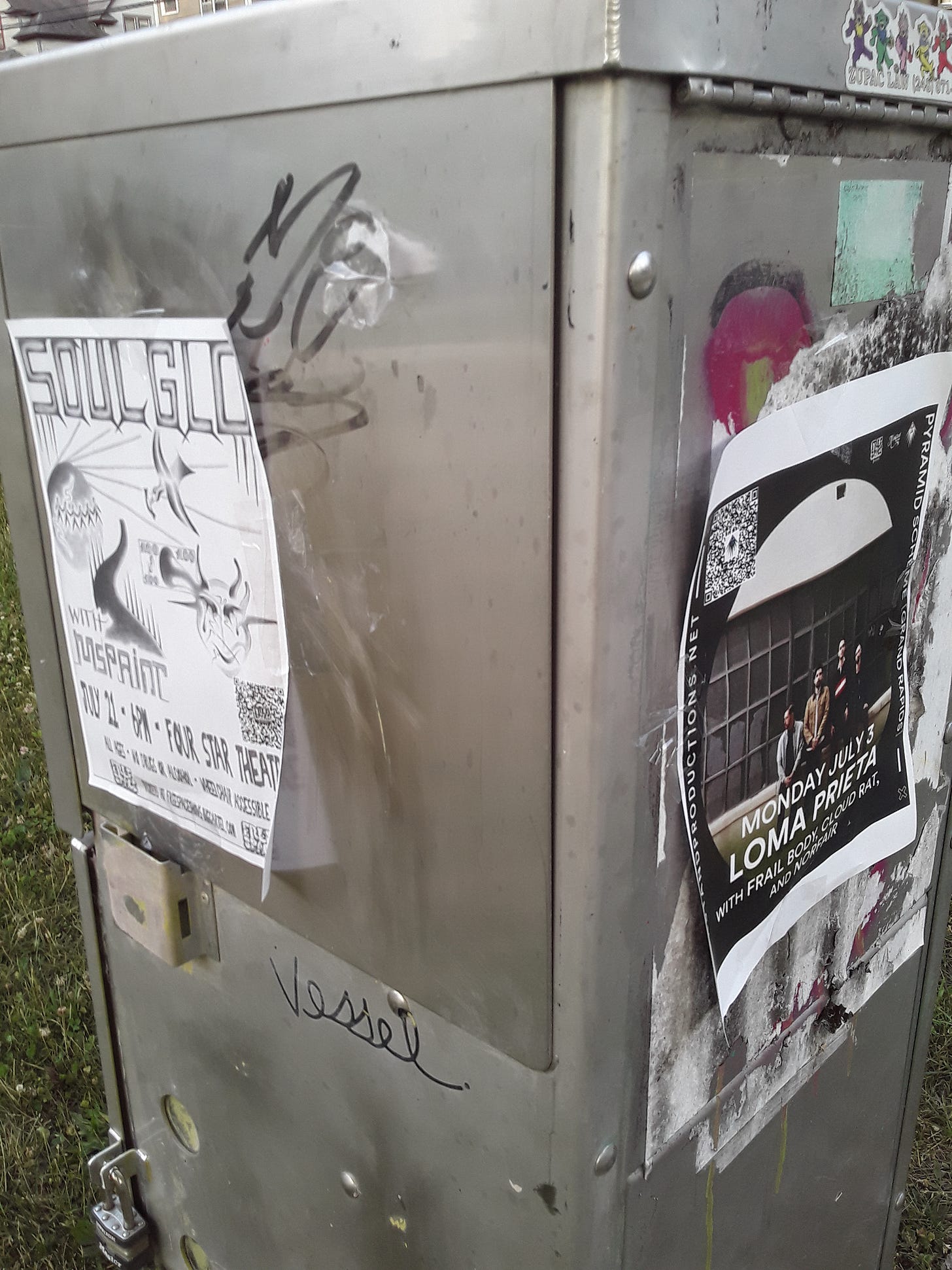 Photograph of two signs illegally attached to electric box in Davis Street Park, looking southwest.