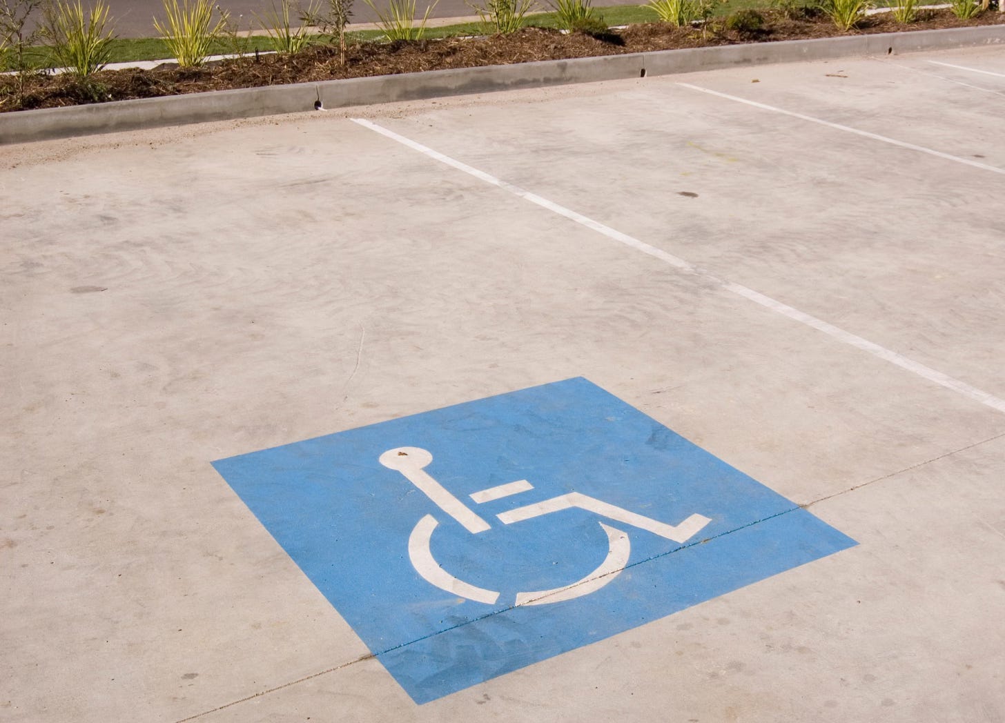 Wheelchair symbol painted onto the pavement of a parking space
