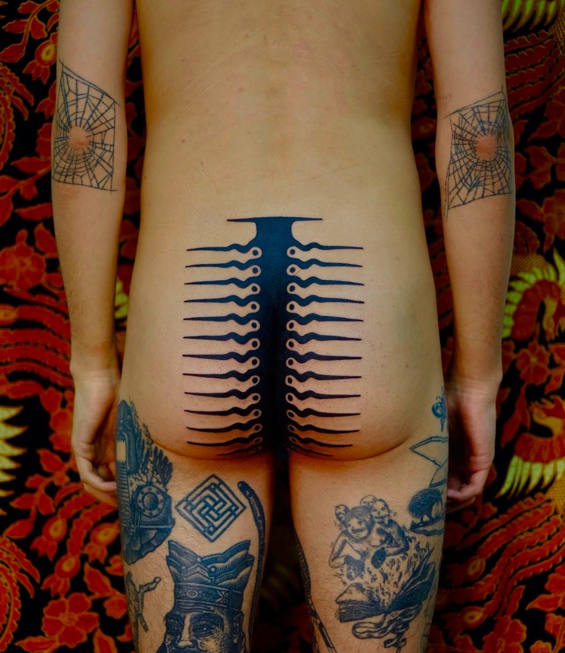 tribal tattoo on rear end of fair skinned male figure