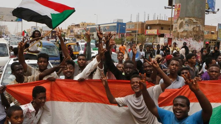 Sudanese people celebrate in the streets of Khartoum after ruling generals and protest leaders announced they have reached an agreement on the disputed issue of a new governing body on July 5, 2019