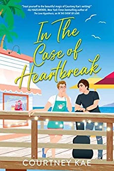 Courtney Kae's book In The Case of Heartbreak. Two illustrated white men stand next to each other on the deck of a seaside cafe or restaurant. Palm trees and sun umbrellas in the background.