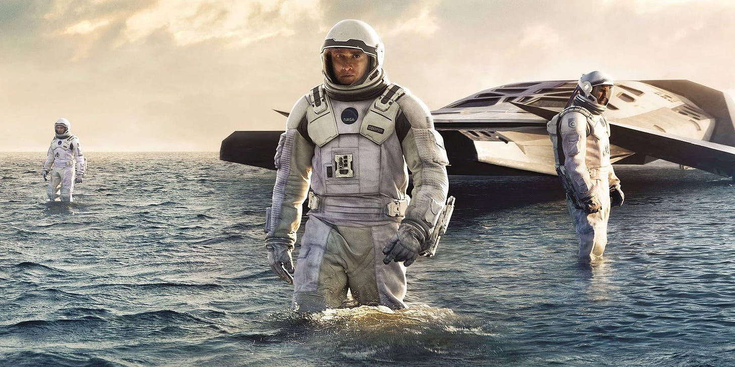 Matthew McConaughey as Cooper wearing a spacesuit standing in a body of water on the poster for Interstellar