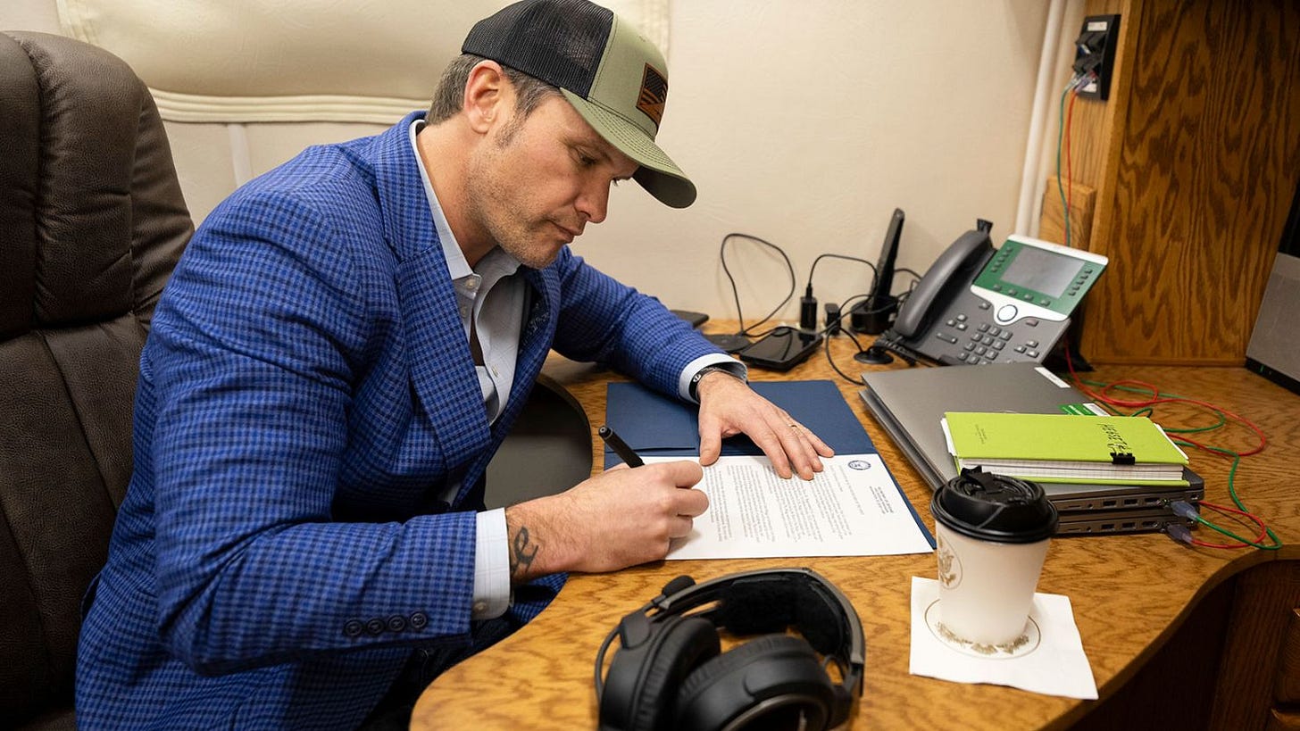 Secretary of Defense Pete Hegseth signs a memorandum reversing the name of Fort Liberty back to Fort Bragg while en route to Stuttgart, Germany, on February 10, 2025.