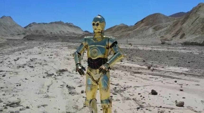 A fan dresses as C-3PO in Death Valley.