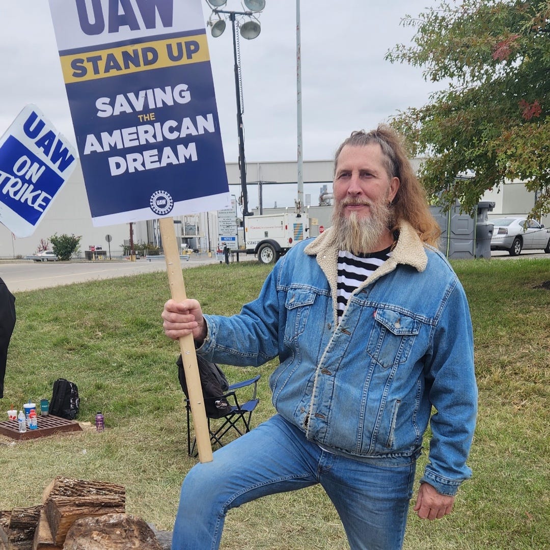 May be an image of 1 person and text that says 'UAN STAND UP SAVING AMERICAN THE DREAM RIKE ON UAW'