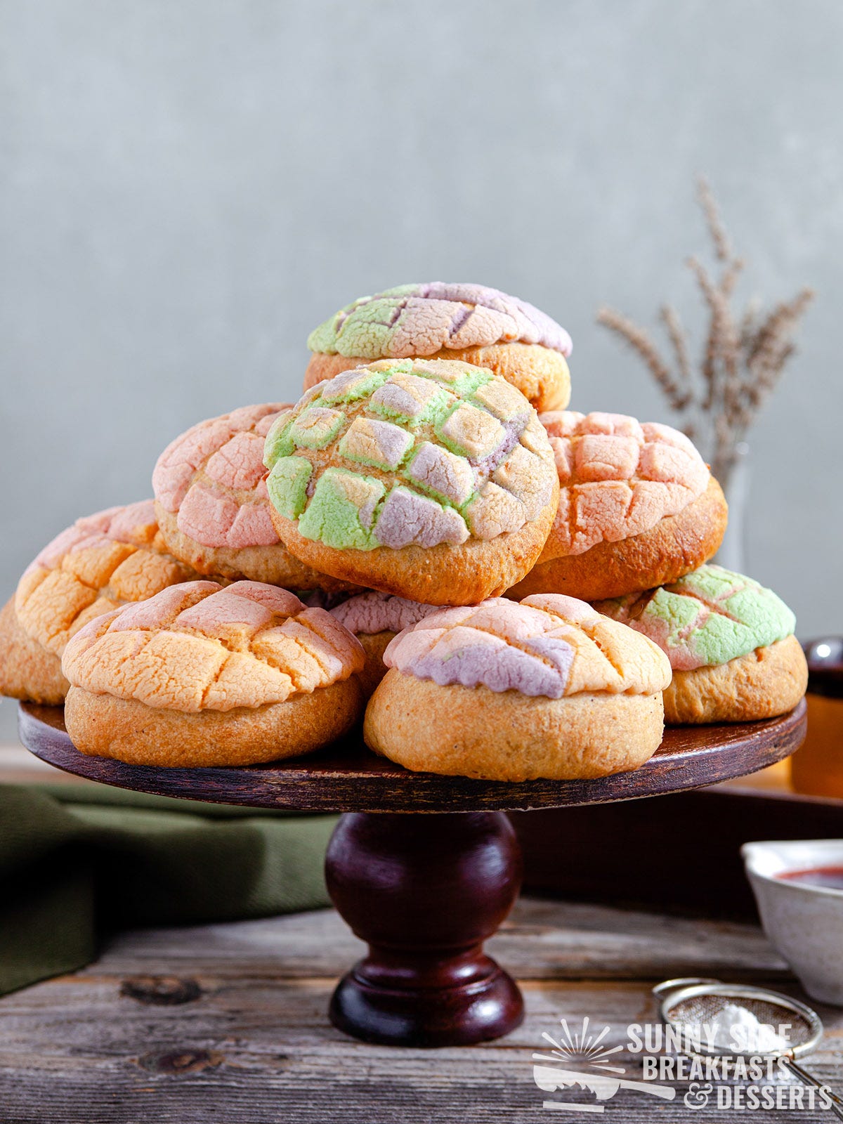 Rainbow conchas on a cake stand.