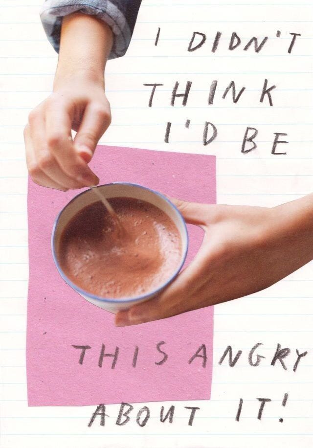 A hand stirs a cup of frothy hot chocolate with a stick. The background features torn pink paper and lined notebook paper. Overlaying text reads, “I didn’t think I’d be this angry about it!” in a handwritten style.