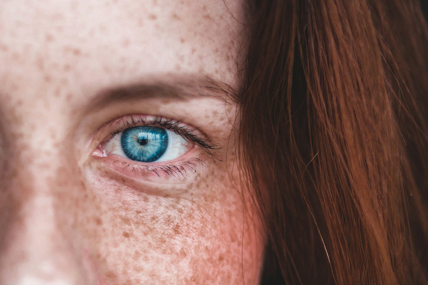 a woman with indigo eyes and auburn hair.