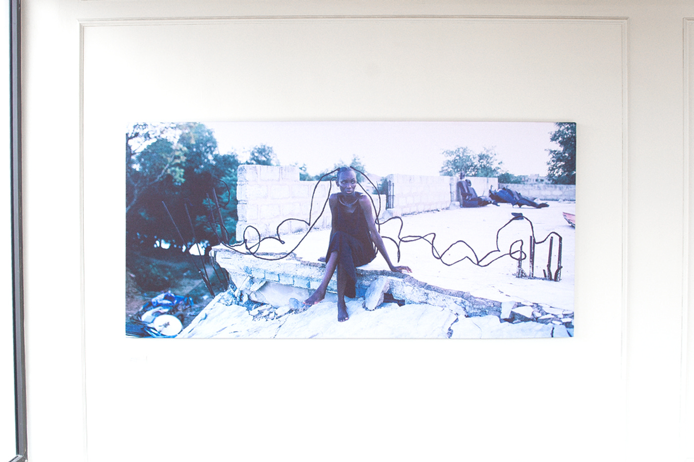 A photo of a model at a construction site with braids from her hair stretching to iron beams on her left and her right.