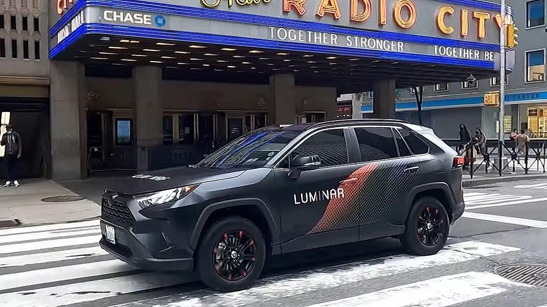 A Luminar-labeled black 4x4 car parked outside Radio City, New York